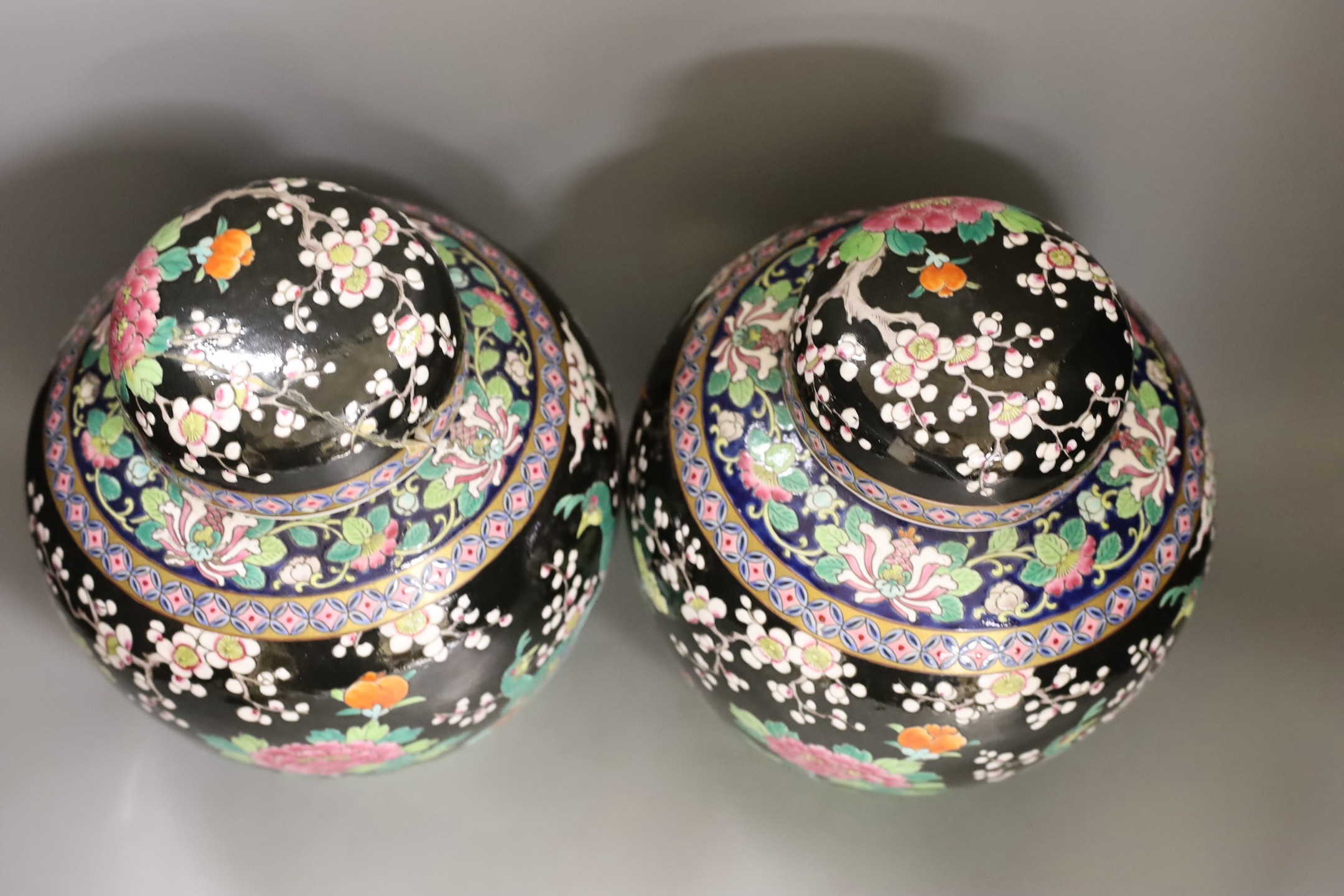 A pair of Japanese famille noire jars and covers 27cm